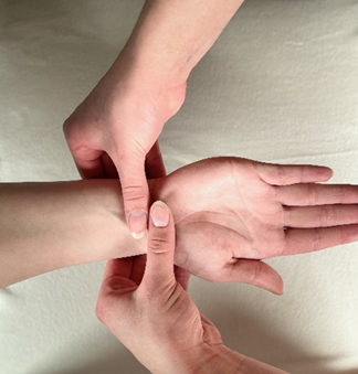 Healthcare provider pushes down on the middle of the patient’s wrist with 2 thumbs.